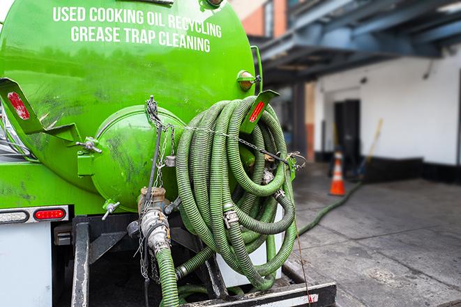 a vacuum truck pumping out a large underground grease trap in Davie